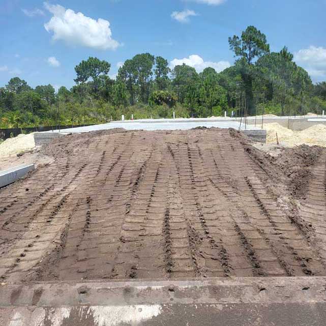 Construction site with tire tracks in dirt.