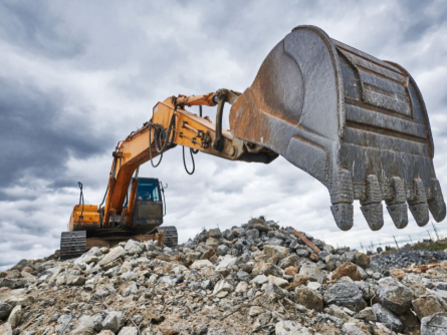 Excavator digging rocks on a construction site.