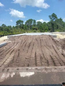 Construction site with tire tracks in dirt.